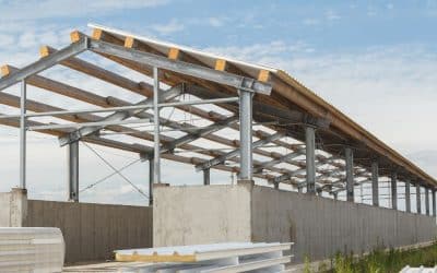 Steel-framed industrial building under construction with concrete walls
